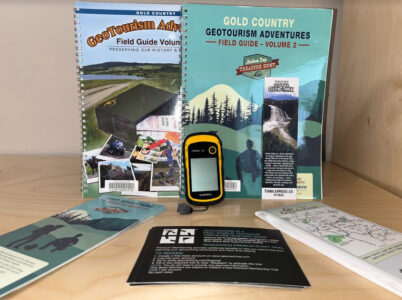 Geocaching kit that has a gps, pamphlets, and guides to geocaching in the area